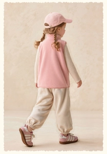 Rear view of girl in pink fleece vest and beige knit set with matching baseball cap