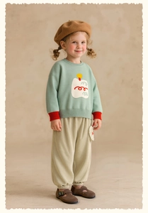 Full-body shot of a girl wearing a sage green knit sweater and beige corduroy pants set