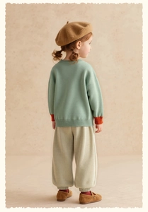 Detail of girls mint green knit sweater and beige corduroy trousers for autumn wear