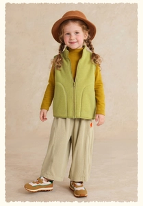 Close-up of green fleece vest paired with mustard sweater and beige corduroy trousers