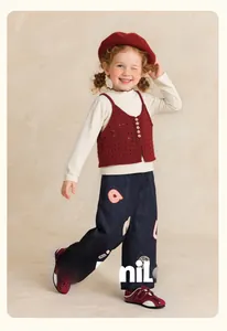 Detail of girls casual navy pants with letter patches and a red knit vest outfit