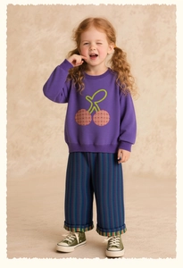 Detail of purple cotton sweatshirt with cherry embroidery and striped wide-leg pants