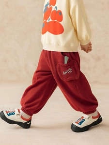Girls' casual outfit with cream sweatshirt and red corduroy pants with apple pockets