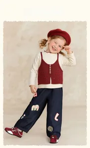 Detail of girls' wide-leg denim pants featuring cute alphabet patches and pocket styling
