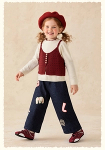 Detail of girl's blue denim jeans with cute cartoon patches and embroidered letters