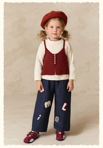 Full view of girl's vintage outfit with red vest and patched wide-leg denim jeans