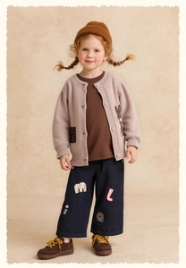 Detail of girls knit cardigan and embroidered navy jeans outfit with a beanie