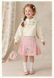 Détails d'une tenue chinoise pour fille avec broderie florale et jupe en velours rose