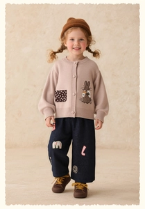 Detail of girl's navy blue casual trousers with letter embroidery and patches