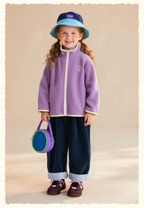 Dettaglio giacca in pile color lavanda con ricamo a coniglio e pantaloni di velluto