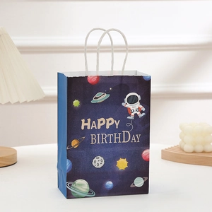 Détail du sac cadeau en papier astronaute bleu avec poignée blanche et logo d'anniversaire