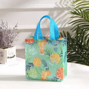 Waterproof non-woven tote bag with summer fruit print and blue handles on white table