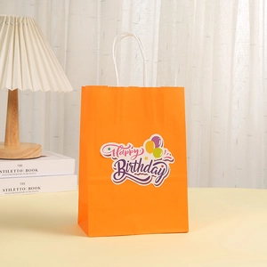 Sacchetto regalo in carta kraft arancione con adesivo Happy Birthday e manici bianchi