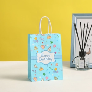 Blue paper birthday gift bag with festive illustrations and white rope handles