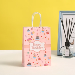 Pink paper gift bag with birthday cake illustrations and Happy Birthday message
