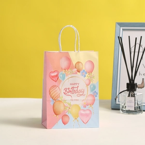 Detailed close-up of a colorful Happy Birthday paper gift bag with white rope handles