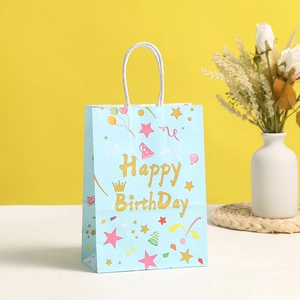Light blue Happy Birthday gift bag with white rope handles and festive gold lettering