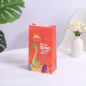 Sac cadeau en papier rouge avec illustration de dinosaure vert et décor tropical ludique