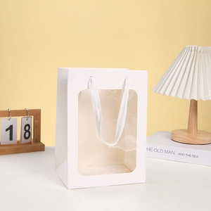 Detailed view of white marble pattern gift bag with transparent window and fabric handle
