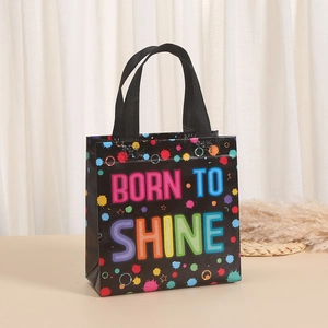 Detail of waterproof non-woven gift bag with colorful Born to Shine print and woven handles