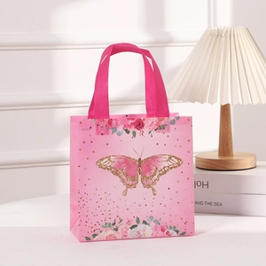 Rosa Schmetterling Geschenkbeutel aus Vliesstoff mit Blumenmuster auf weißem Tisch