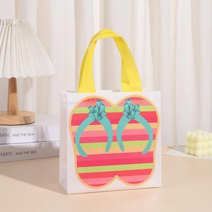 Close-up of white non-woven gift bag with colorful flip-flop pattern and yellow handles