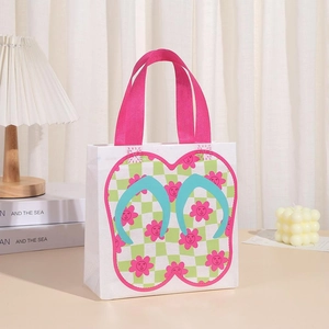 Detailed view of white non-woven gift bag with pink handles and flip-flop pattern