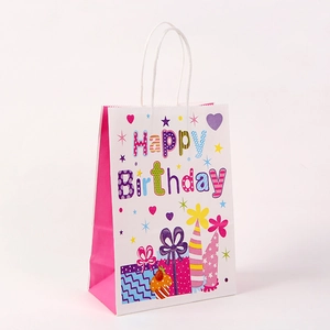 Close-up of white birthday gift paper bag with colorful Happy Birthday text and rope handle