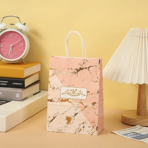 Detail of pink marble gift bag with gold foil floral pattern and white rope handles