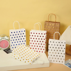 Detailed close-up of colorful gold foil polka dot paper gift bags with twisted handles