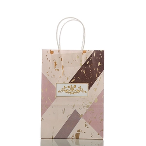 Geschenktüte mit Marmormuster, Goldrosen-Logo und weißen Papiergriffen für Geschenke