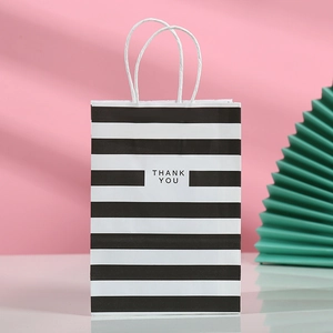 Bolsa de regalo de papel a rayas blancas y negras con asas blancas y frase Thank You