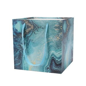 Teal marble pattern paper gift bag with golden sand texture and ribbon handles