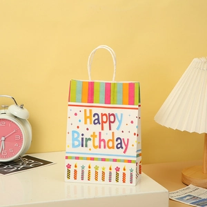 Detail of Happy Birthday kraft paper bag featuring colorful candles and white handles