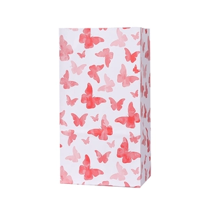 Détail du sac cadeau en papier blanc avec d'élégants motifs papillon aquarelle rose