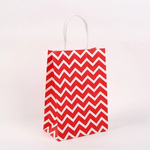 Rote und weiße Geschenktüte aus Kraftpapier mit Chevron-Muster und weißen Griffen