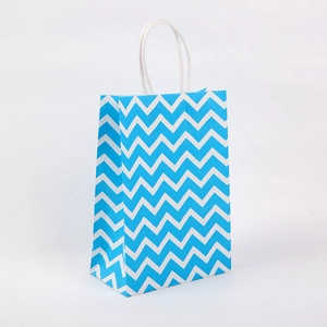 Geschenktüte aus Kraftpapier mit blau-weißem Wellenmuster und weißen Seilgriffen