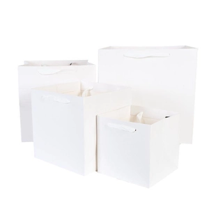 Set of four white cardboard gift bags with elegant ribbon handles in various sizes