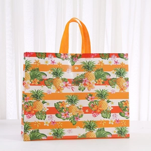 Detail of large non-woven tote bag with orange stripes and tropical pineapple print