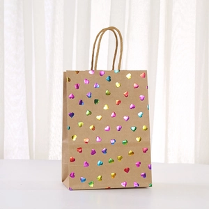Motif de cœurs métalliques colorés sur sac cadeau en papier kraft avec poignées