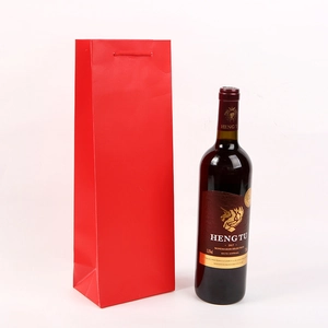 Vertical red paper wine gift bag with matching handles shown next to a 750ml wine bottle