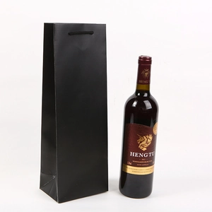 Vertical matte black wine gift bag with woven handles shown next to a 750ml bottle