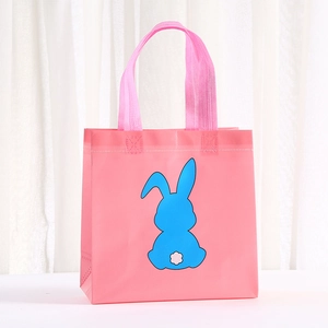 Detailed view of pink non-woven gift bag with blue rabbit silhouette and reinforced handles