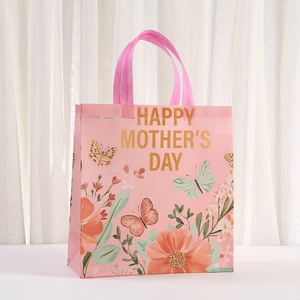 Close-up of pink Mother's Day gift bag with floral prints and golden lettering