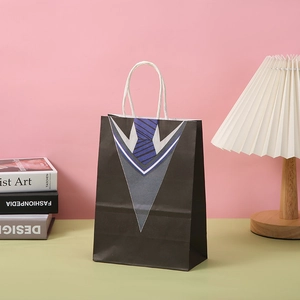 Detalle de bolsa de regalo negra con diseño de traje, corbata y asas de cuerda blanca