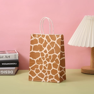 Geschenktüte aus Papier mit Giraffenmuster, weißen Kordelgriffen und Wellenschnitt