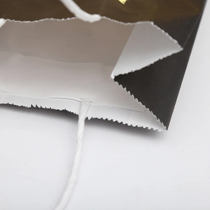 Close-up of black gift bag with reinforced white rope handle and clean interior finish
