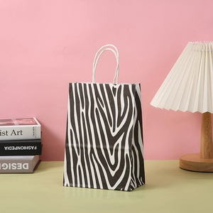 Zebra-Geschenktüte aus Papier mit weißem Kordelgriff in modernem Lifestyle-Ambiente