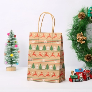 Detail of Christmas kraft paper gift bag with reindeer and tree prints and paper handles