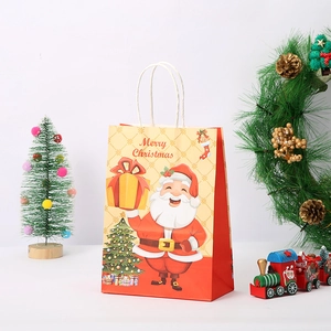 Detail of Christmas kraft paper gift bag with Santa Claus print and twisted handles